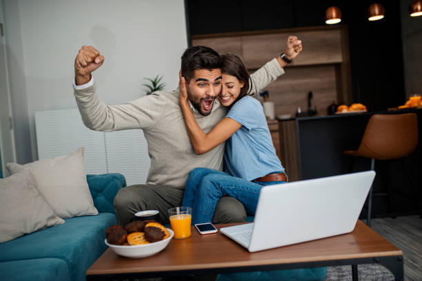 Happy couple relaxed at home, doing some online shopping